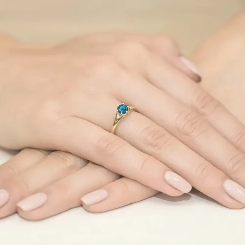 Złoty pierścionek z topazem londn blue 0,50ct i brylantami 0,03ct W0076